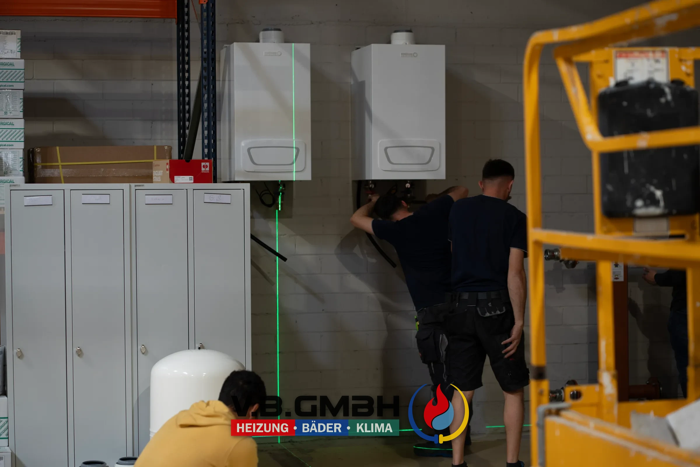 Zwei Monteure arbeiten mit Laser an Heizanlage