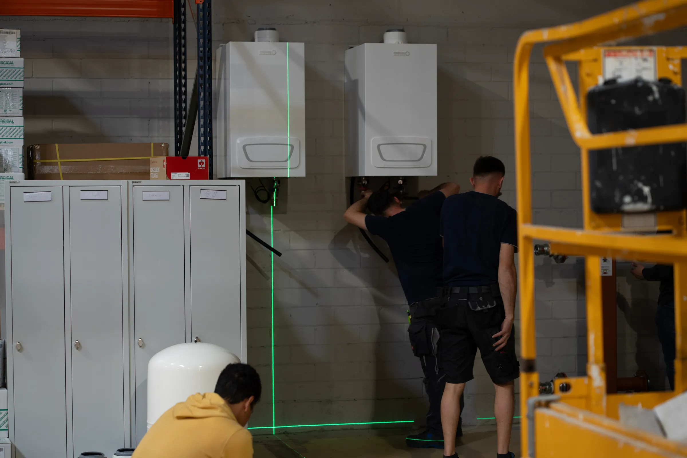 Zwei Monteure arbeiten mit Laser an Heizanlage