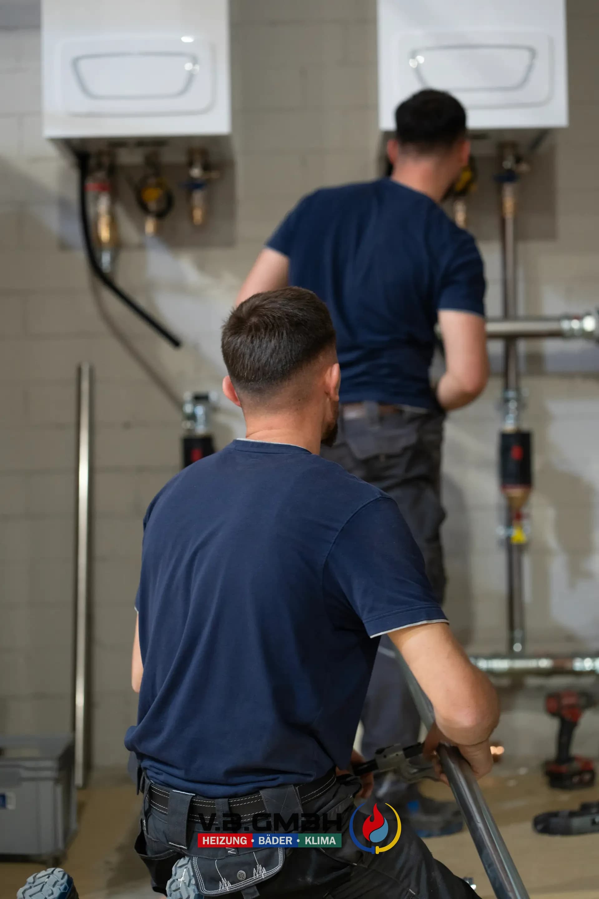 Zwei Monteure vor fertig installierter Heizungsanlage