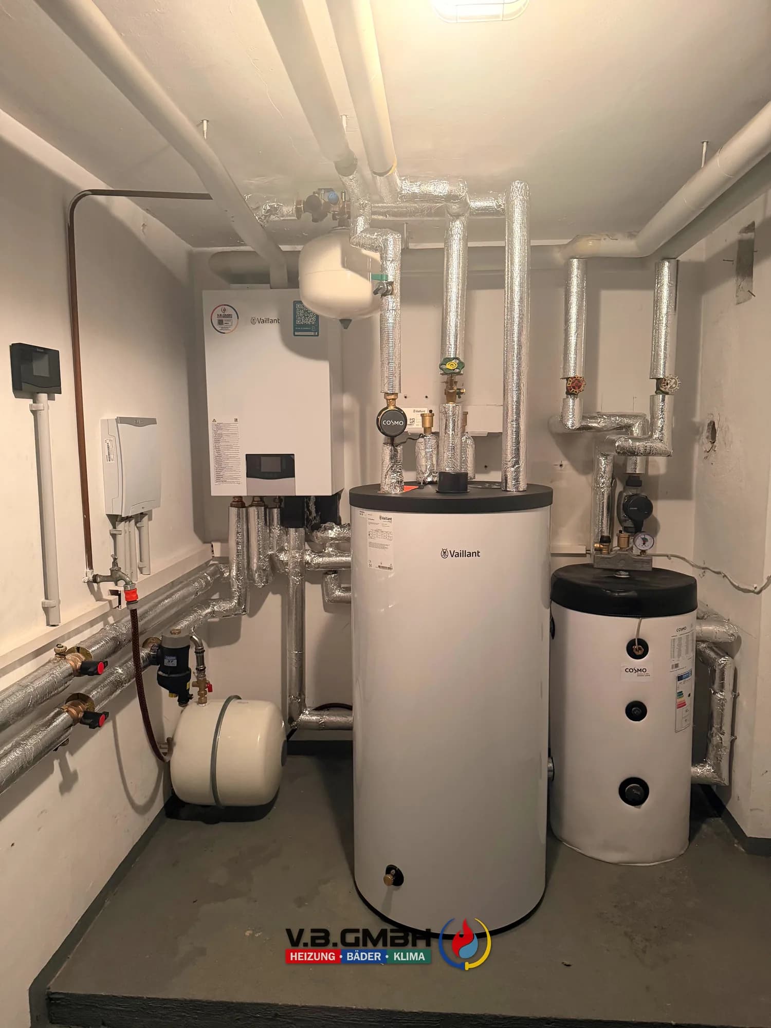 Vaillant Heizgerät mit Speicher und Heizkörper an roher Betonwand