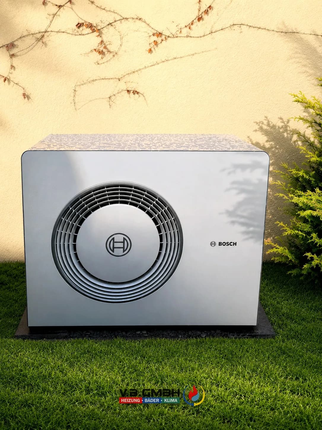 Bosch Wärmepumpe Außeneinheit auf Sockel im Garten an der Fassade installiert