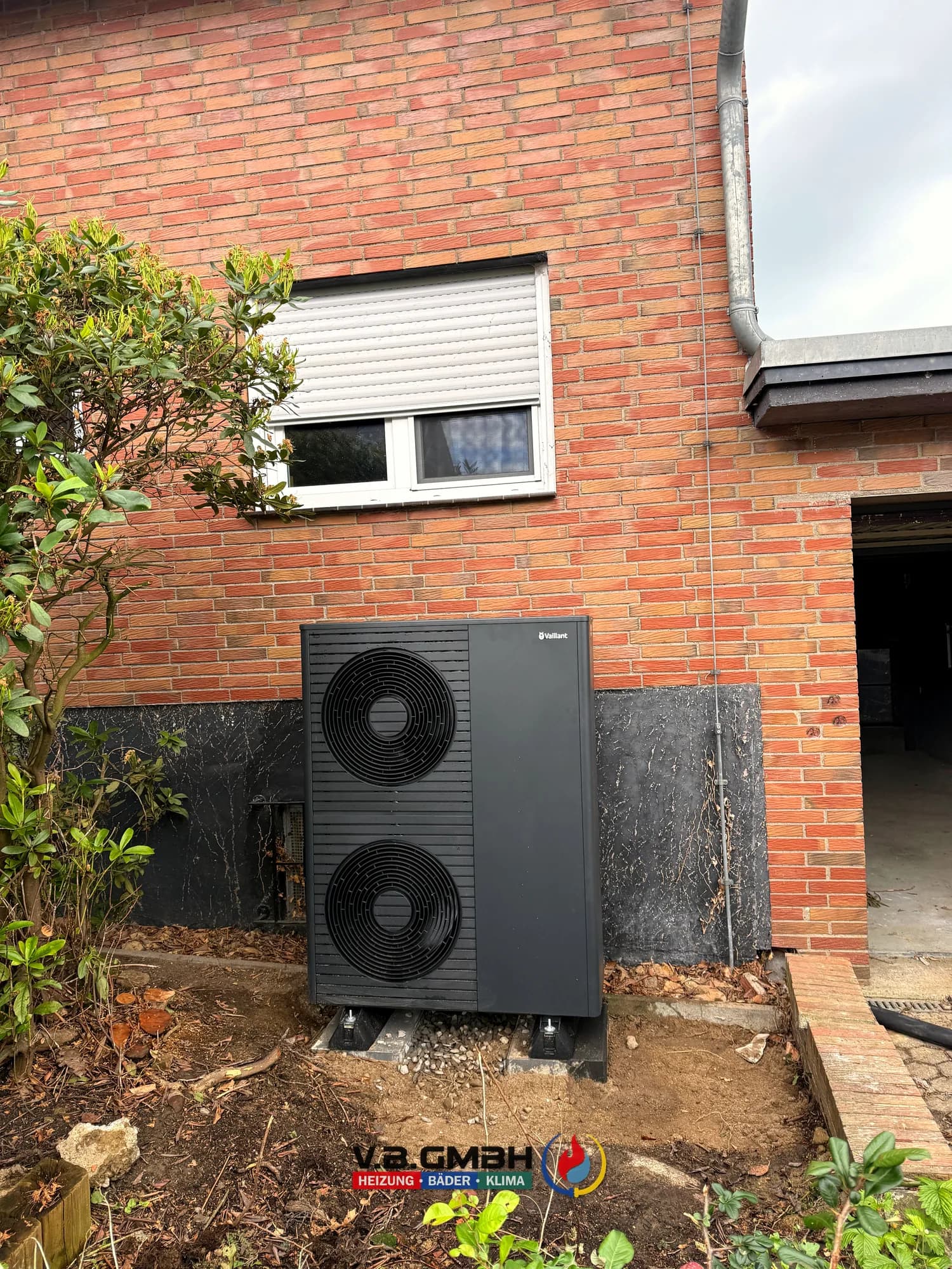 Große Vaillant Wärmepumpe mit zwei Ventilatoren am Klinkerhaus aufgestellt
