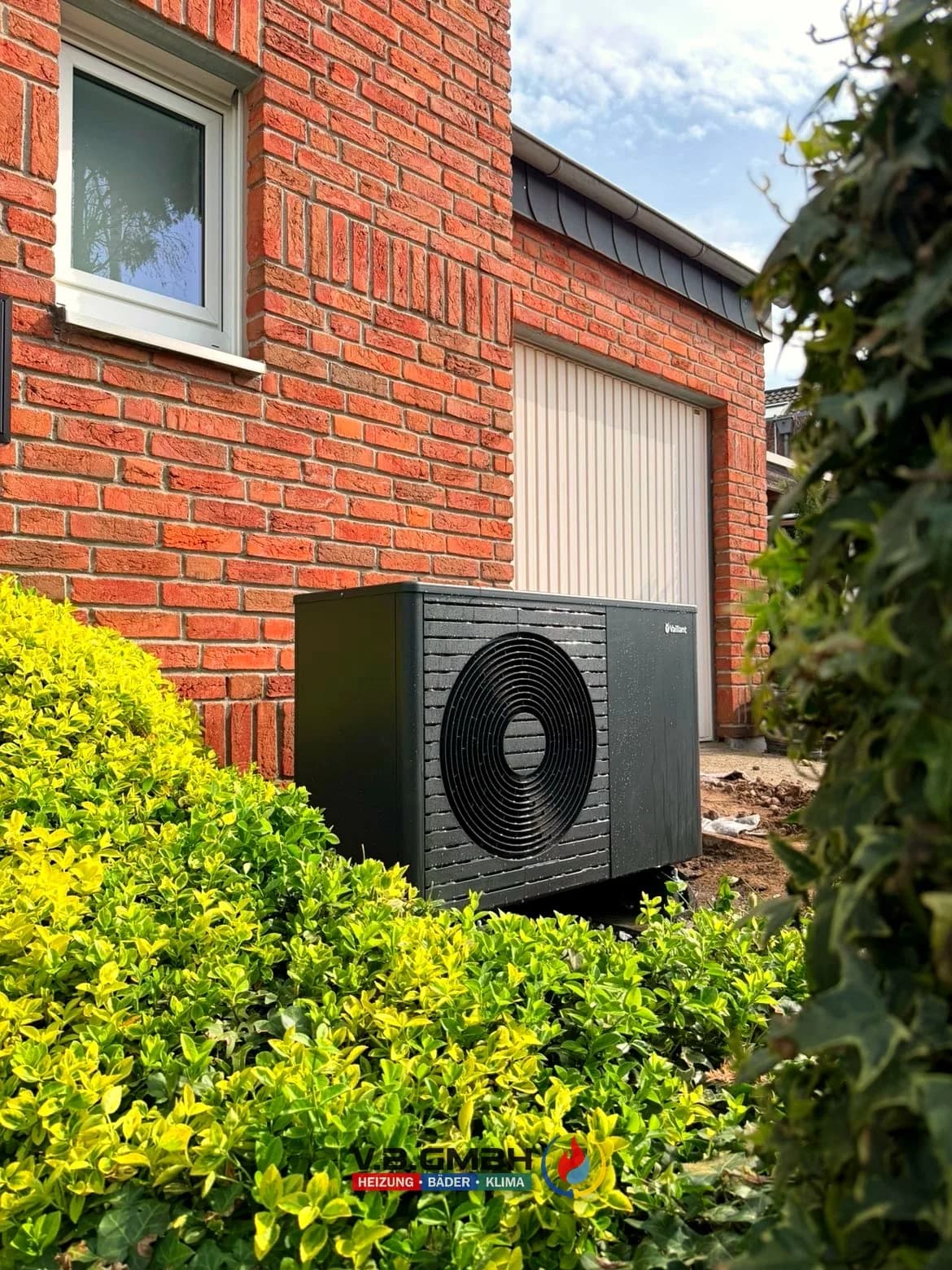 Vaillant Wärmepumpe Außeneinheit an Klinkerfassade neben Garage montiert