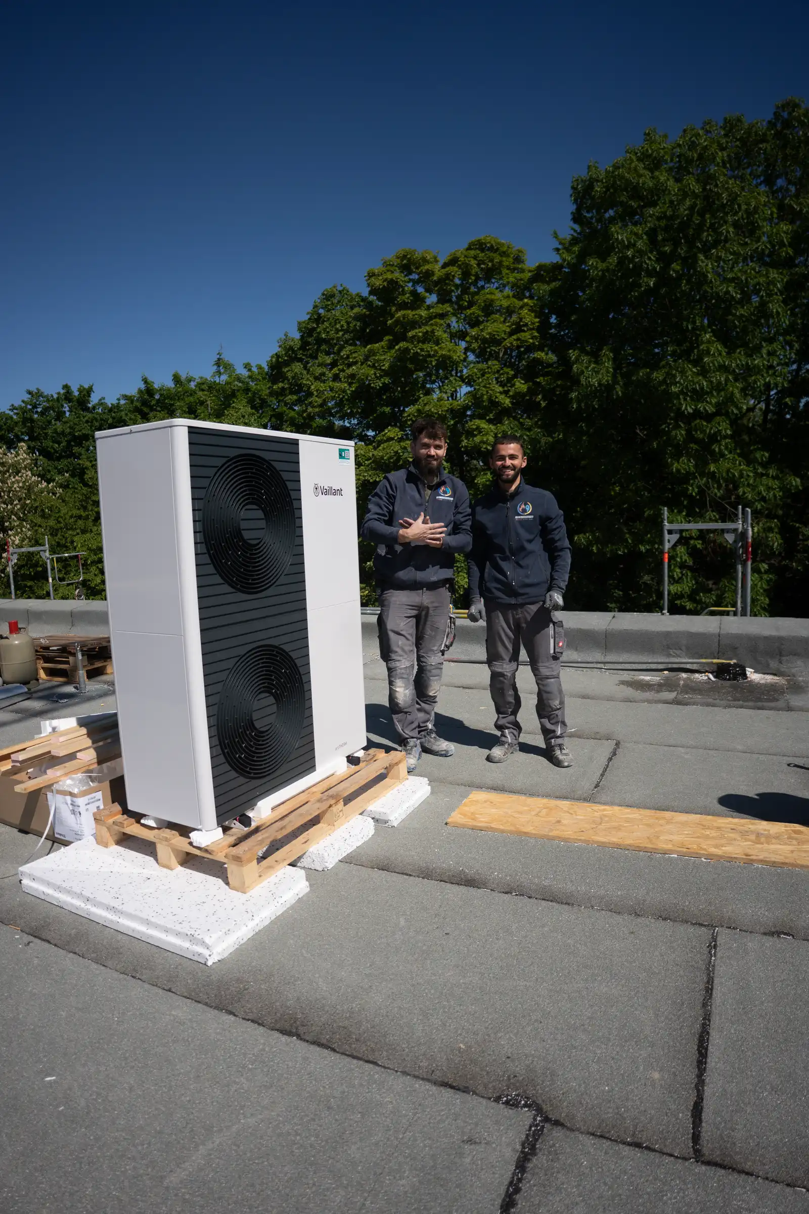 Zwei Monteure mit Vaillant Wärmepumpe bei Montage auf Flachdach