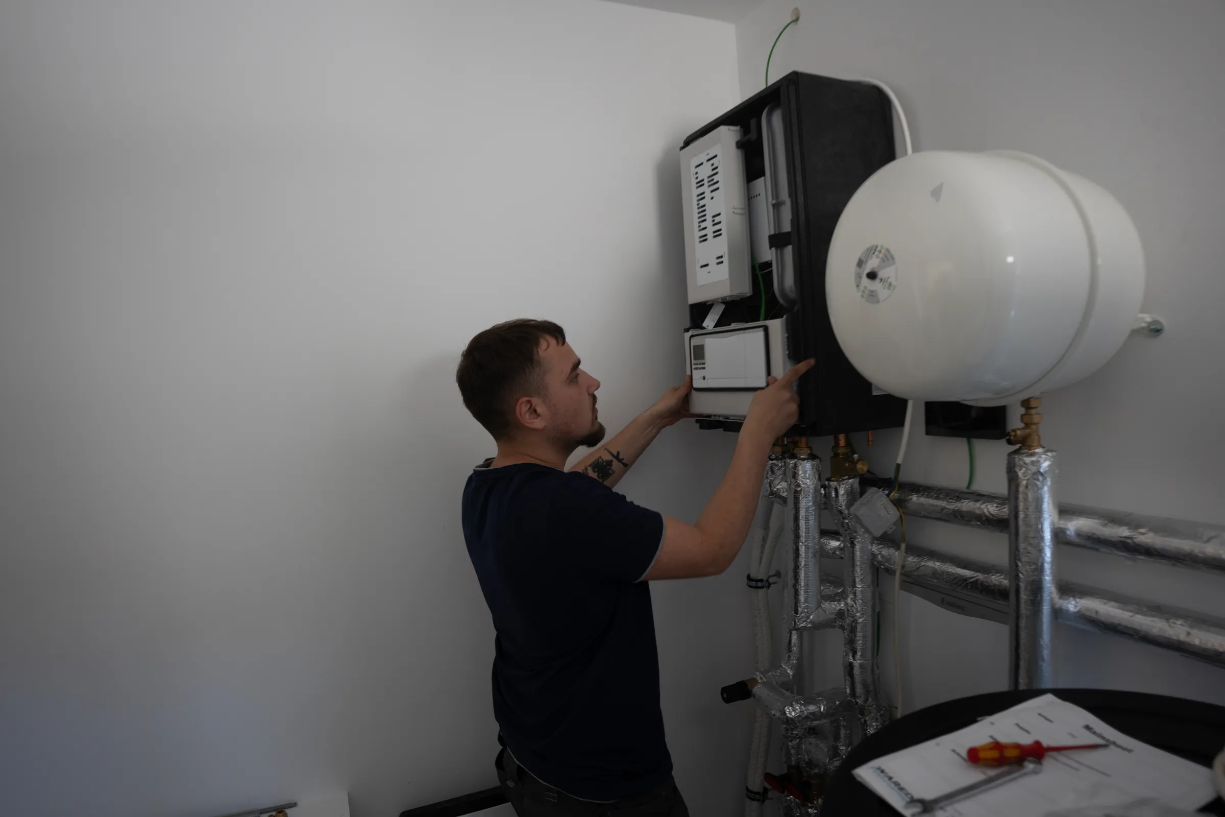 Techniker installiert Heizgerät an Kellerwand