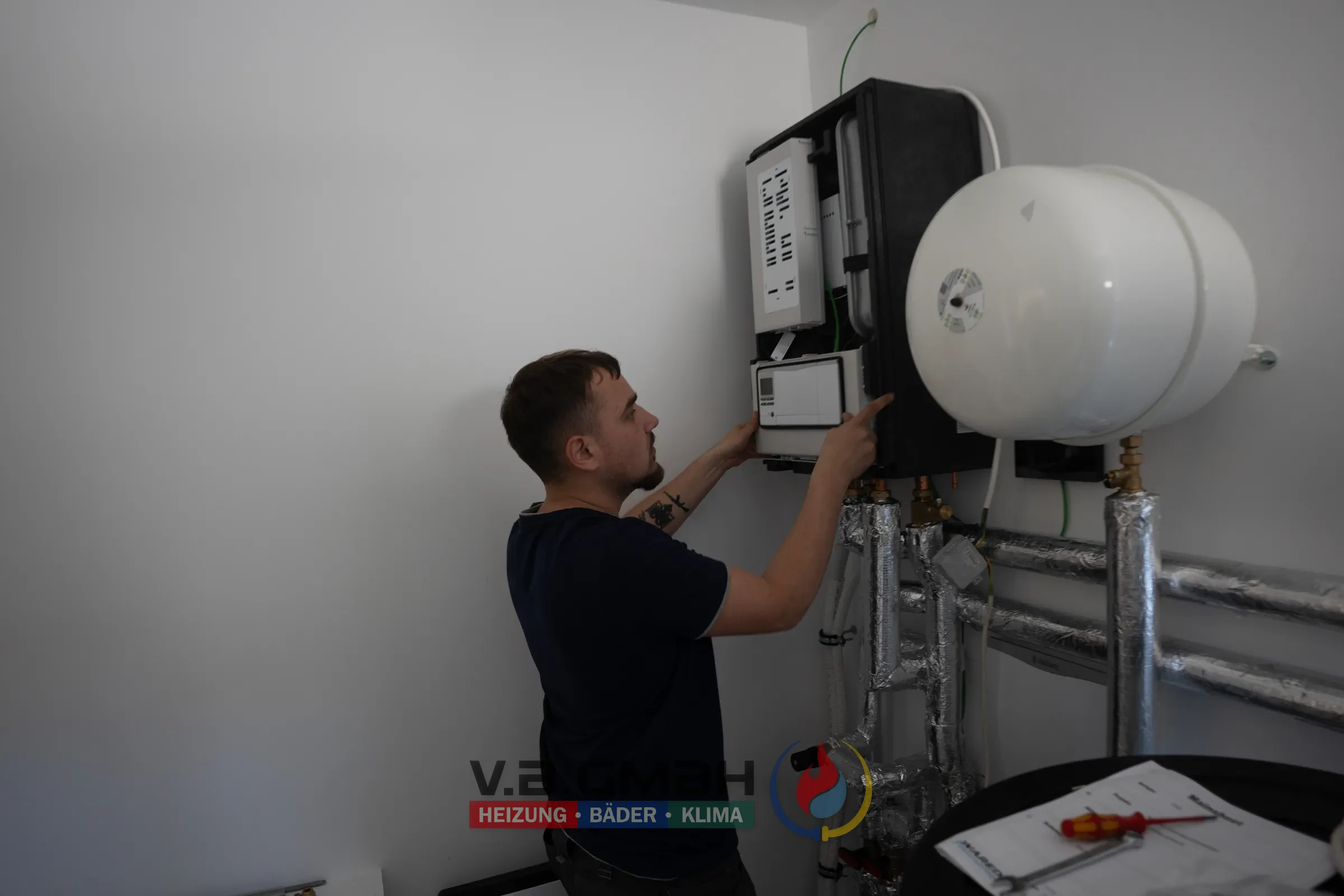 Techniker installiert Heizgerät an Kellerwand