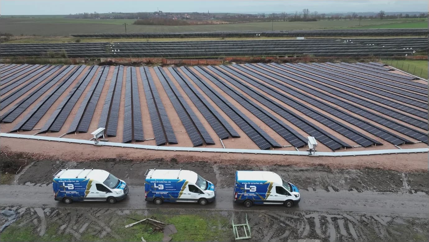 Photovoltaik-Freiflächenanlage (Solarpark) mit dem Fuhrpark von LB-Solartec davor