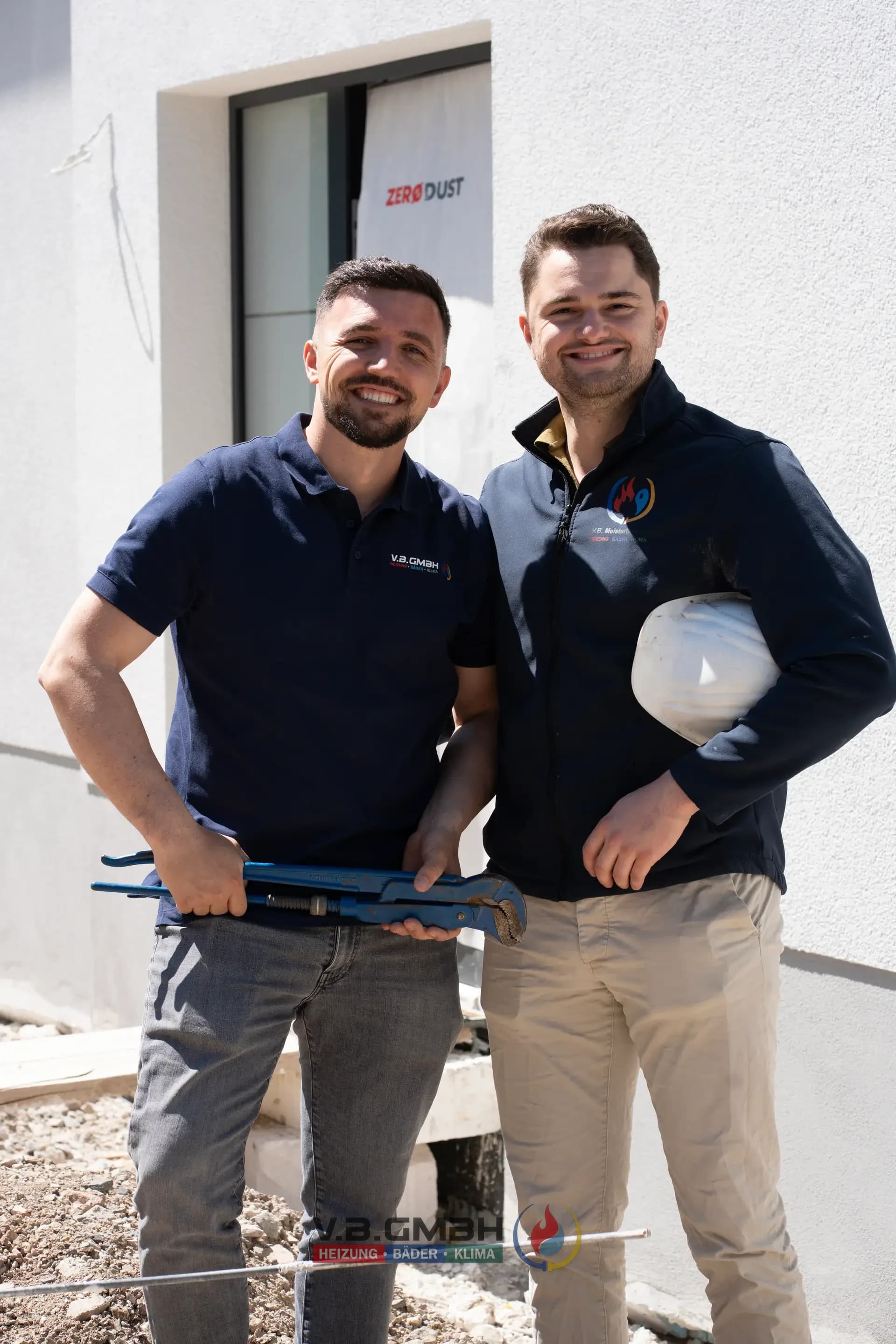 Zwei VB-Mitarbeiter Gruppenporträt lächelnd auf Baustelle