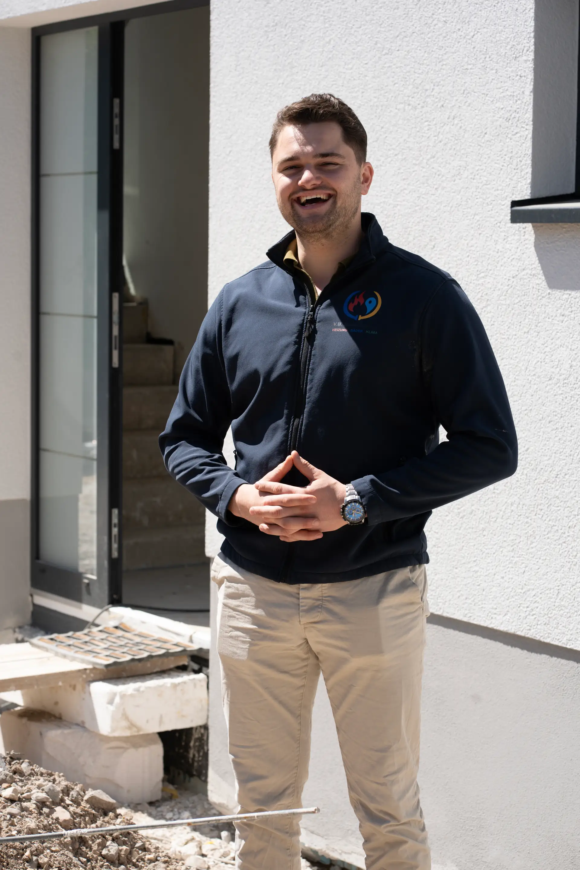 VB-Mitarbeiter Portrait lächelnd vor Hauseingang