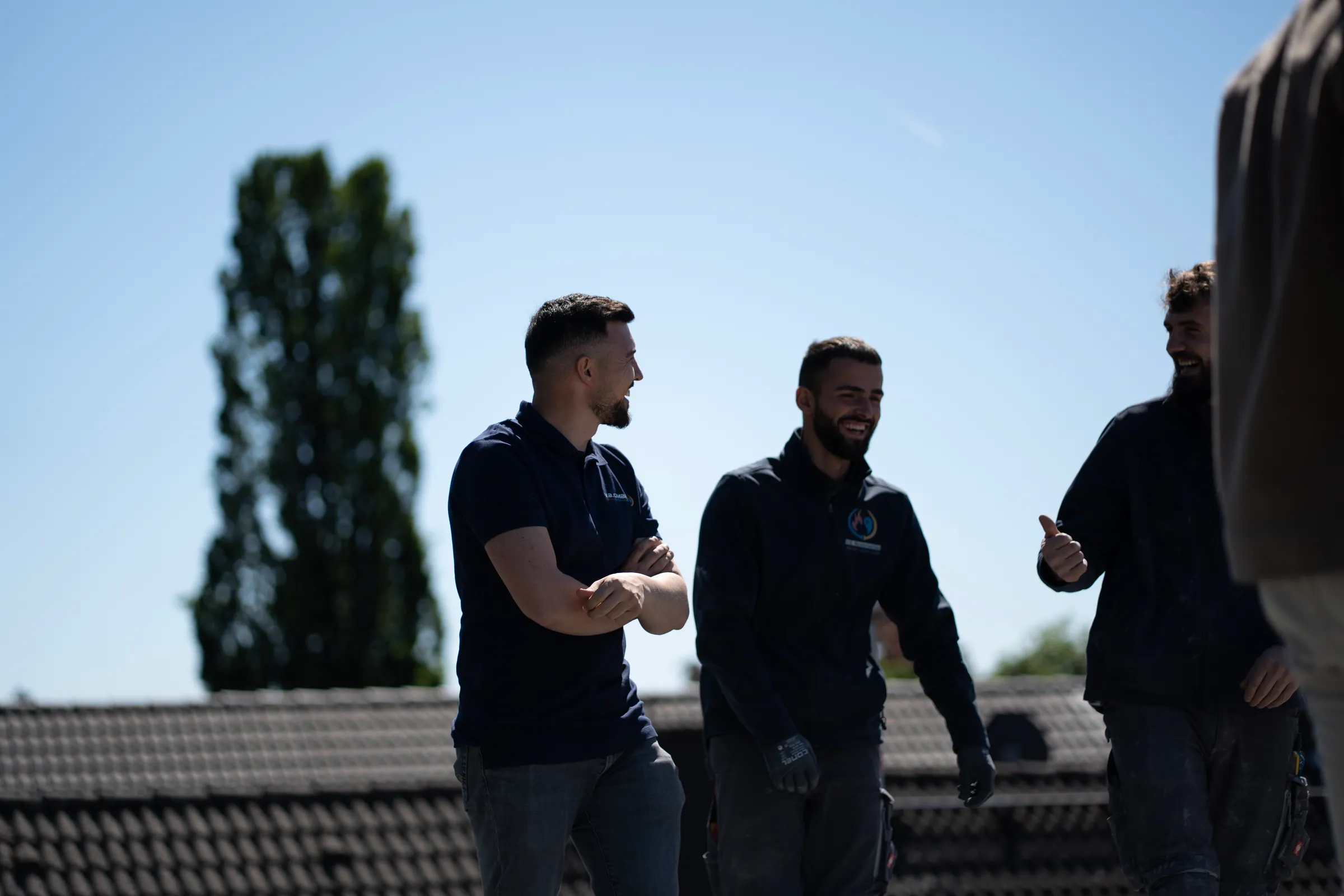 Drei Monteure Gruppenfoto auf Flachdach bei der Arbeit