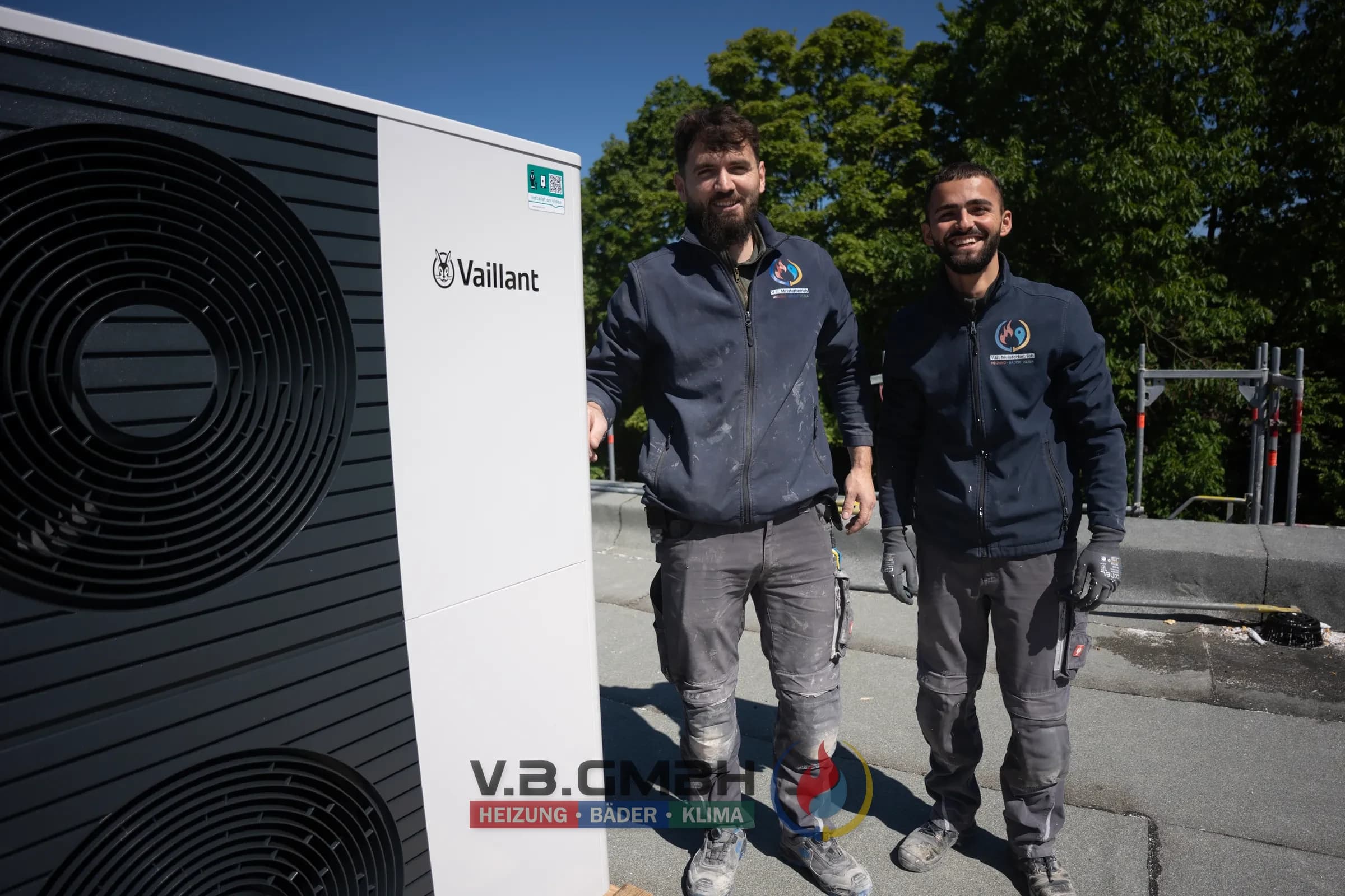 Zwei Monteure vor fertig installierter Vaillant Wärmepumpe auf Flachdach