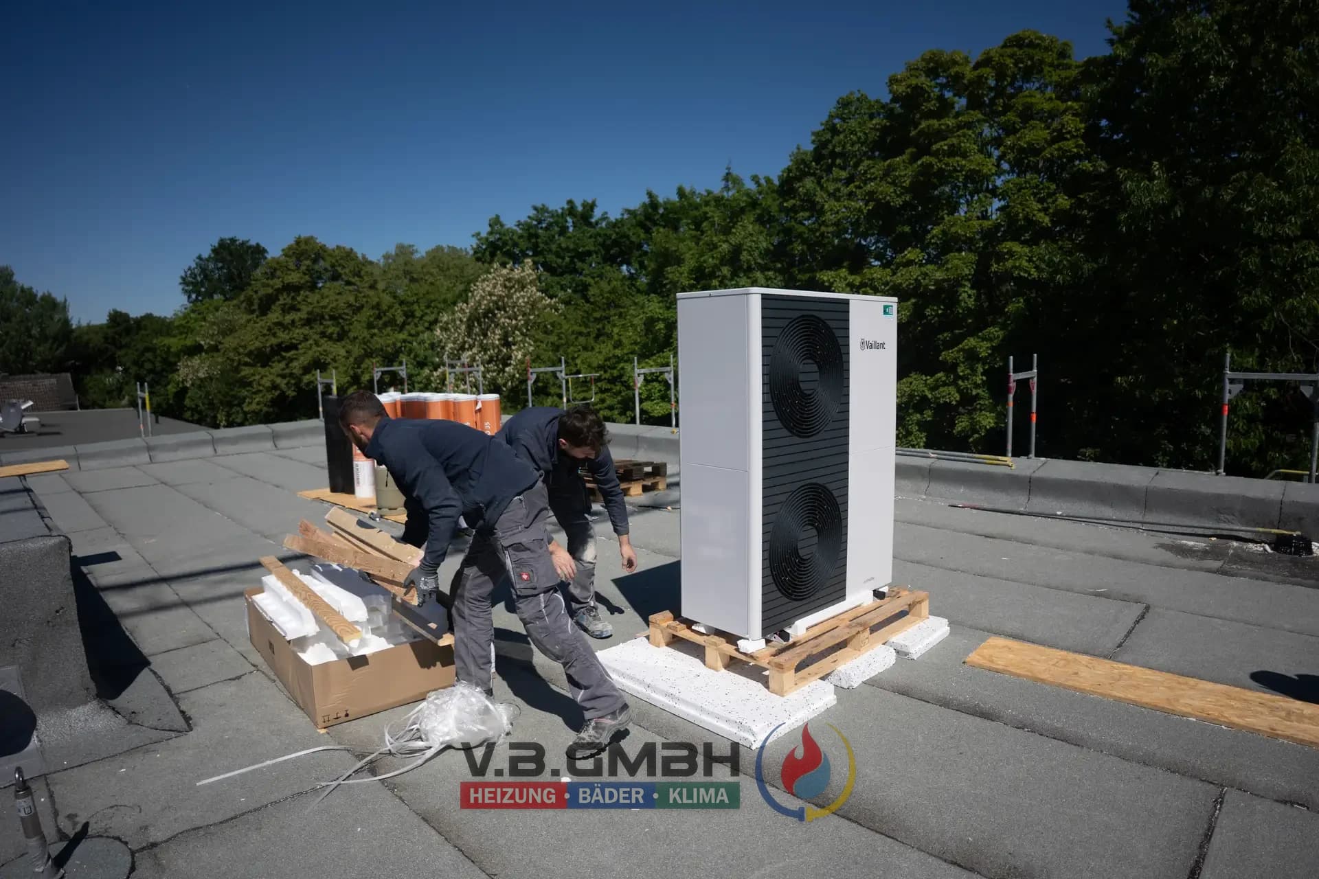 Zwei Monteure installieren Vaillant Wärmepumpe auf Flachdach
