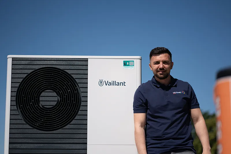 Außenstehende Wärmepumpe mit Person daneben als Illustration für einen Wärmepumpen-Guide